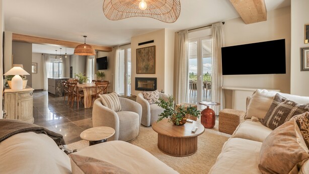 A modern living room with a sofa, coffee table, and dining area.
