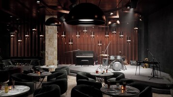 A modern lounge area with seating, a piano, a drum set, and a keyboard.