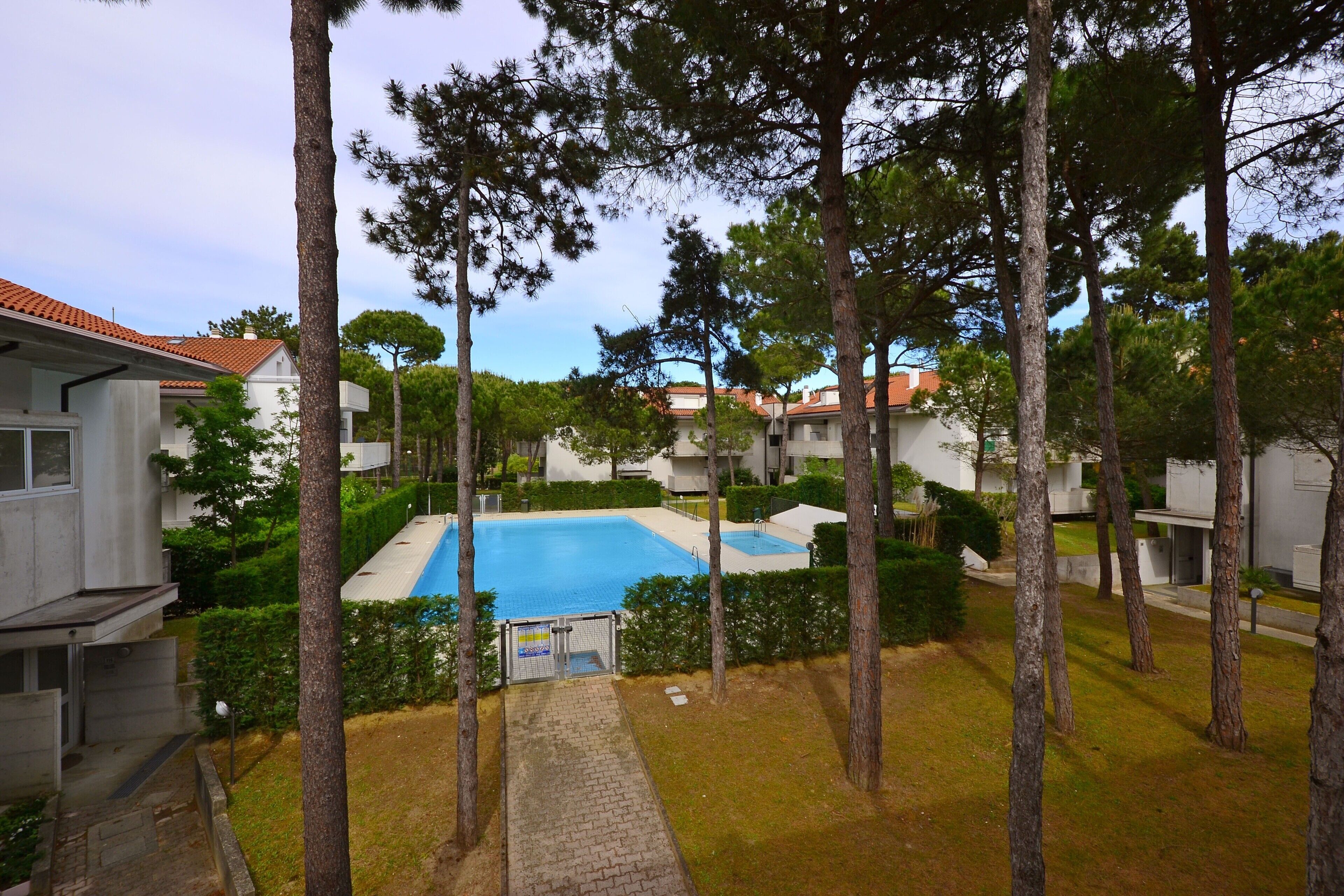 A residential area with a swimming pool surrounded by trees and buildings.
