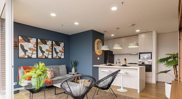 Una cocina moderna con armarios blancos, una isla central e iluminación colgante.