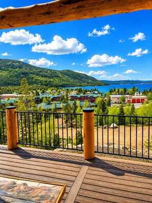 Une terrasse en bois offrant une vue sur un lac et des bĂątiments.