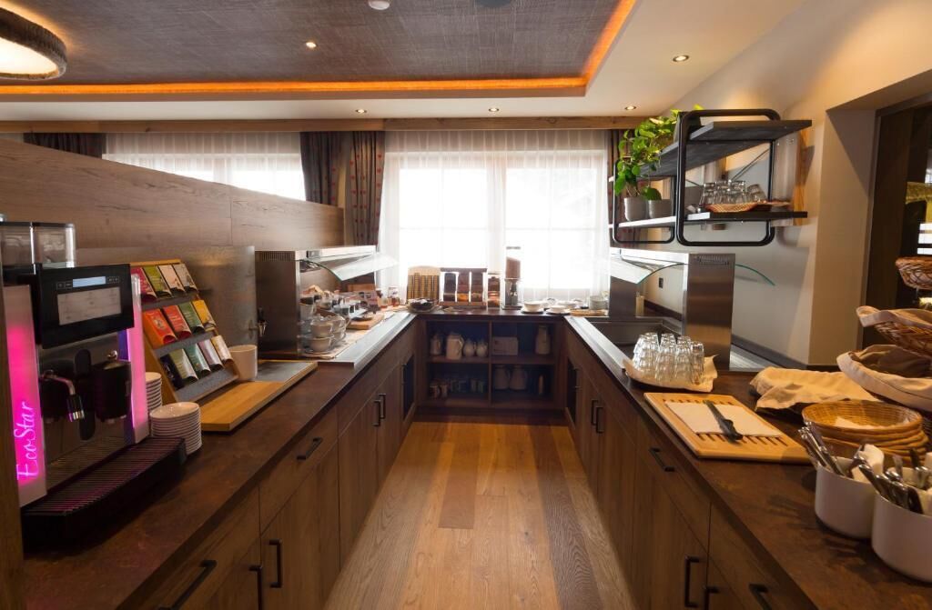 Una cocina moderna con una isla central, electrodomésticos integrados y una zona de café.