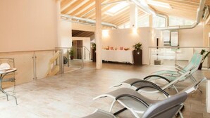Ein großzügiger Innenbereich mit hoher Decke, einer Rezeption, Lounge-Sesseln und einer Treppe.