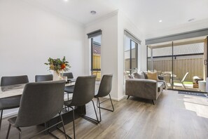 Ein modernes Interieur mit Essbereich, einer Couch und Blick auf den Garten.