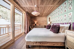 Ein Zimmer aus Holz mit einem Bett, einem Schminktisch und einer Wand mit floralem Muster.