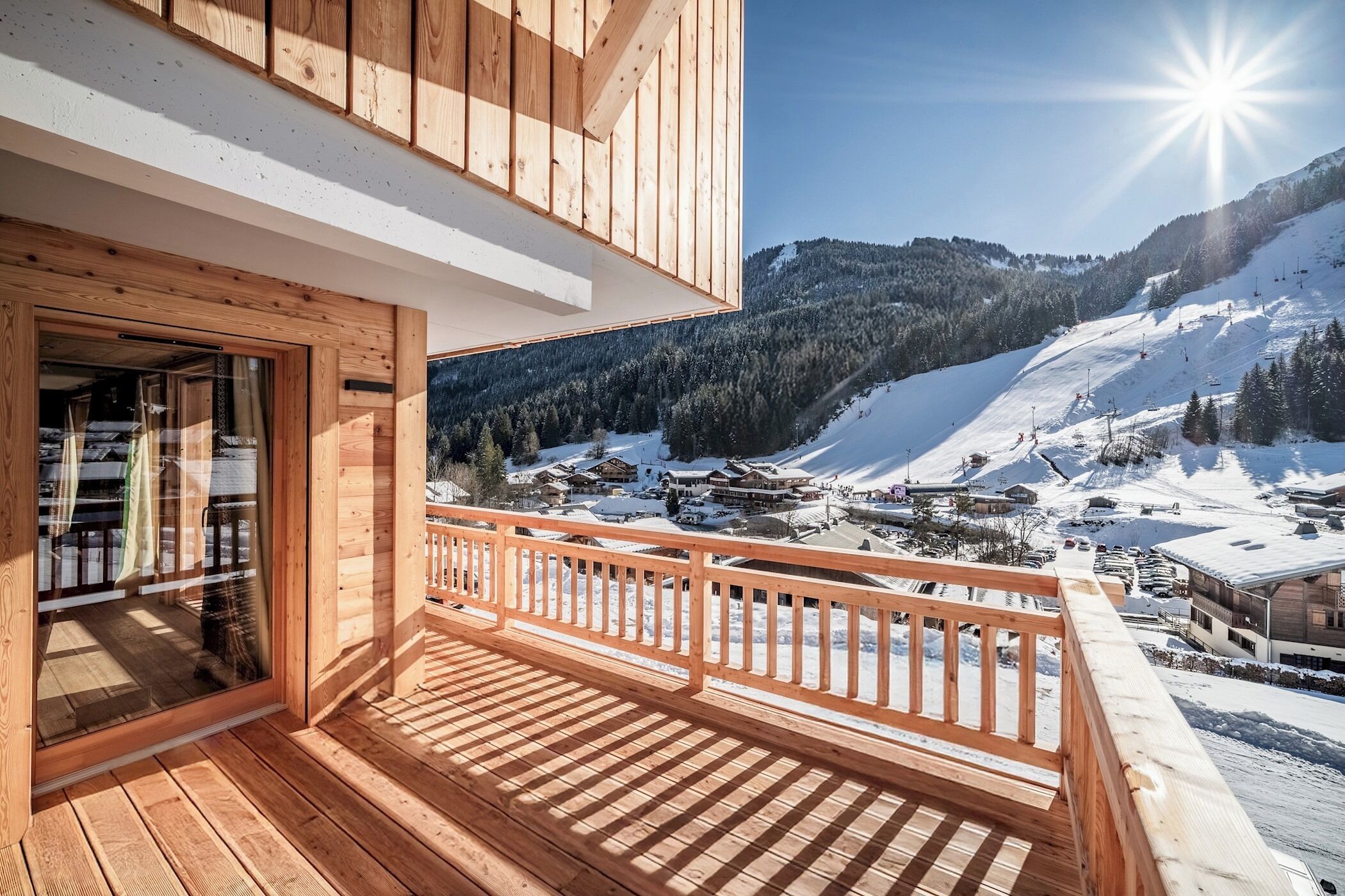 A wooden balcony with a view of a snowy mountain landscape.