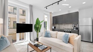 A modern living room with a sofa, coffee table, and a flat-screen TV. - Penthouse "Vivi Milano" in Duomo District + Comfort (Milano)