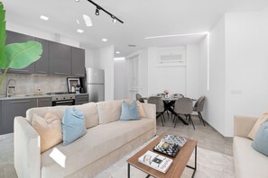 A modern living room with a sofa, coffee table, and dining area. - Penthouse "Vivi Milano" in Duomo District + Comfort (Milano)