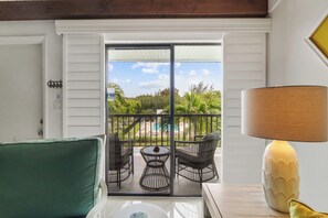 A balcony with outdoor furniture, a view of greenery, and a lamp. - 1 Bedroom, 1 Bath Causeway End of Island! (Sanibel)
