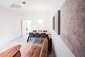 Un salon moderne comprenant un coin repas, une grande fenêtre et une vue sur l’extérieur.