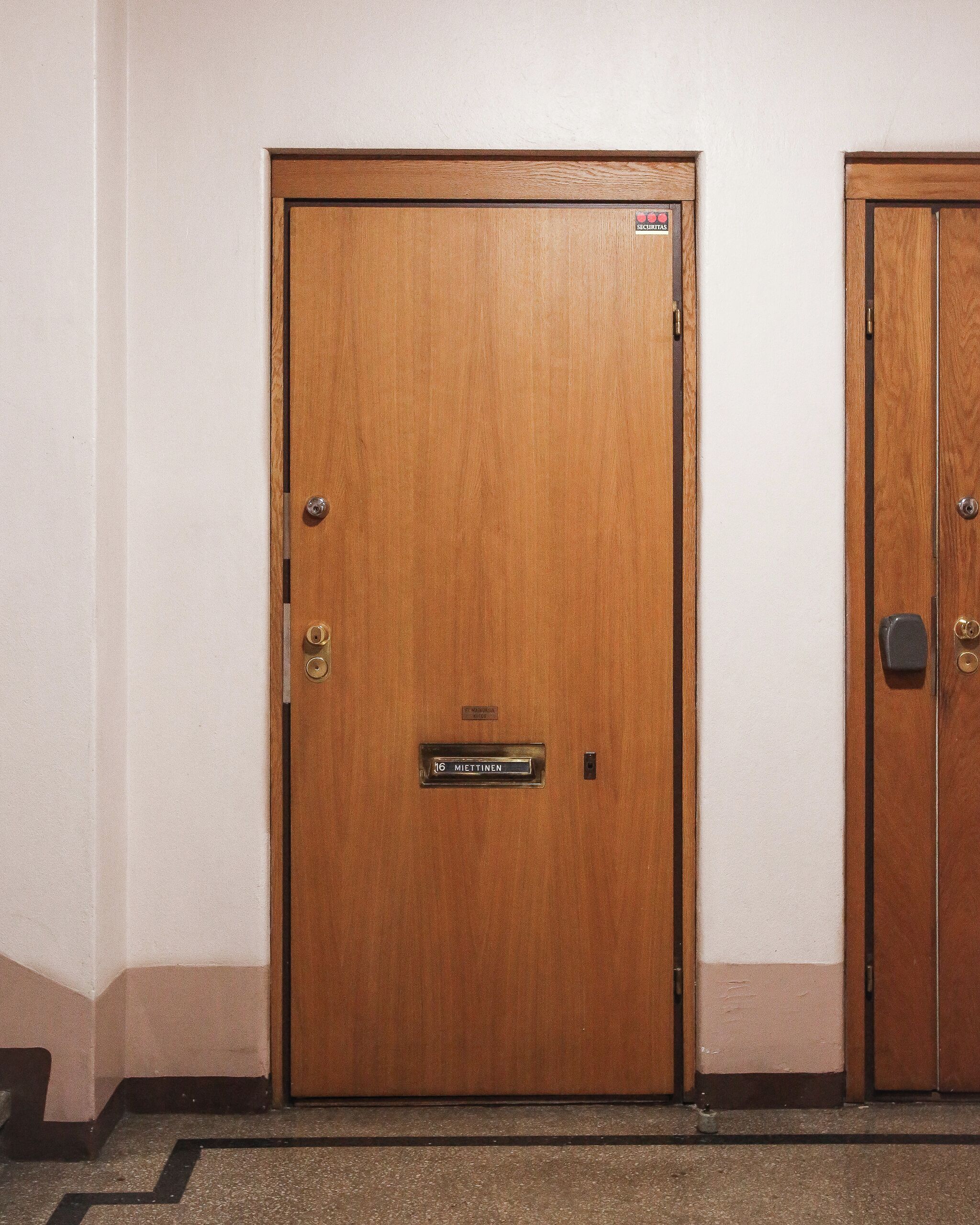 A wooden door with a nameplate reading 'Miettten'.