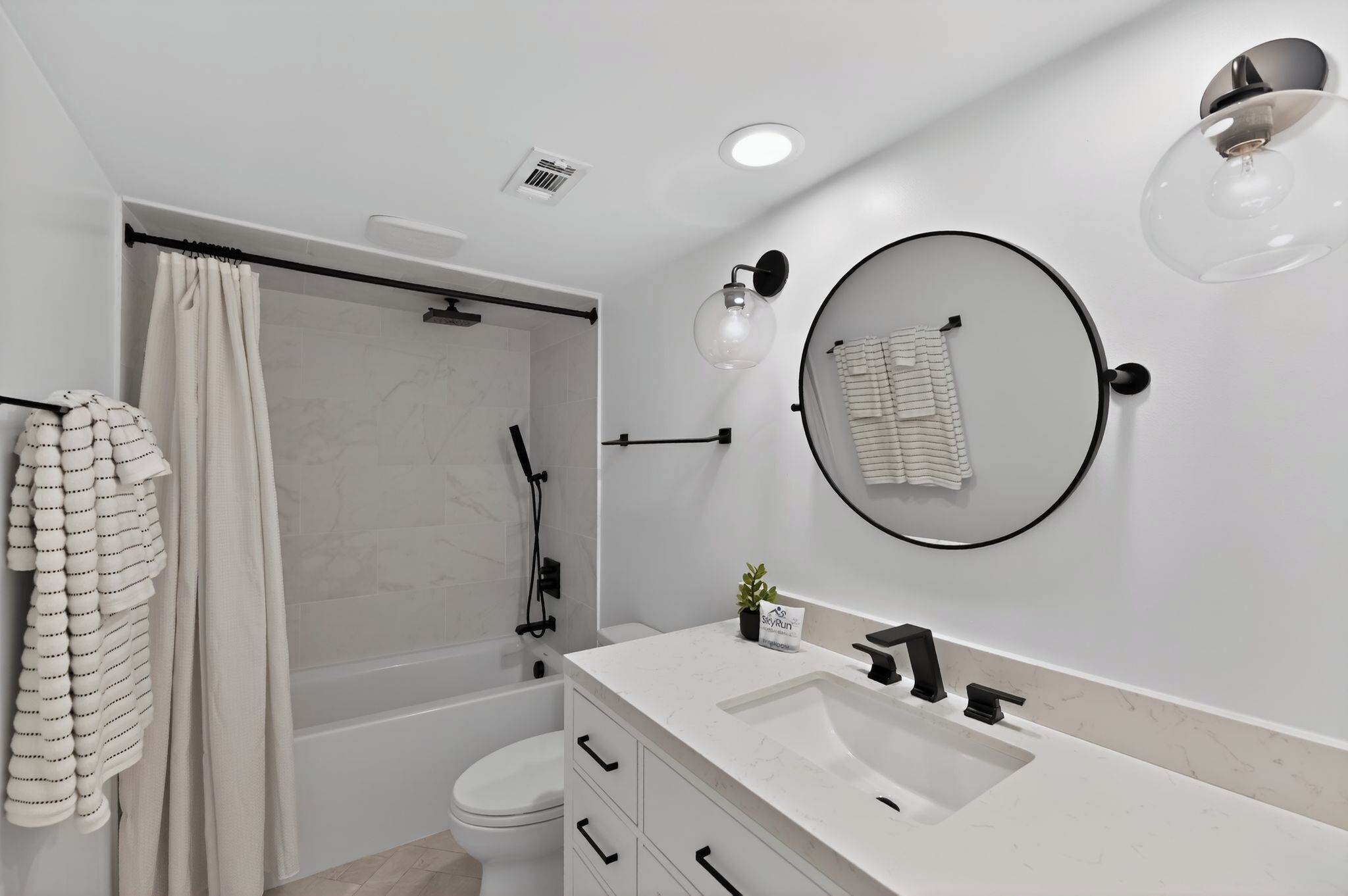 A modern bathroom with a shower, toilet, and sink.