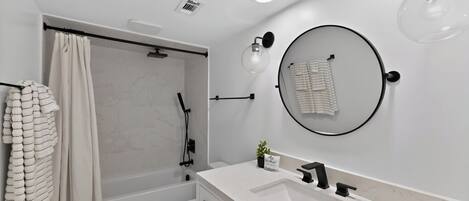 A modern bathroom with a shower, toilet, and sink.