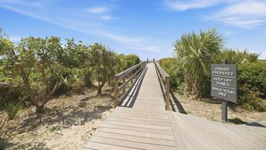 A wooden boardwalk leading through a private property with a sign instructing to keep off dunes and walk your bike. - Seaside Hideaway - Beach Front Luxury! (Johns Island)