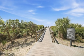A wooden boardwalk leading through a private property with a sign instructing to keep off dunes and walk your bike. - Seaside Hideaway - Beach Front Luxury! (Johns Island)