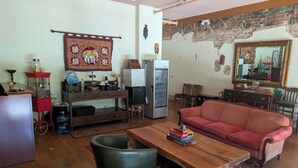 Una sala de estar con un sofá rojo, una mesa de centro de madera y una alfombra estampada.