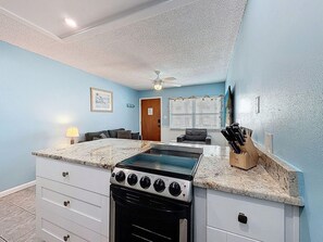 A compact kitchen with a built-in stove, oven, and countertop. - Harbor House 26 (Treasure Island)
