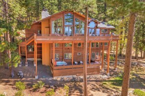 A two-story wooden cabin with a deck, surrounded by trees. - King's View Lodge - Lakeview (Incline Village)