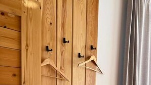 A wooden wardrobe with a hanging rod and a small shelf. - Kemin Guest House (Kaindy)
