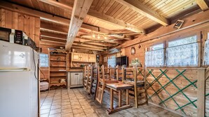 Ein Holzinnenraum mit Küchenzeile, Holzbalken und einem Kühlschrank.