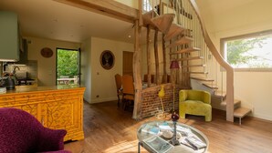 Un vaste espace de vie agrémenté d’un escalier en bois, d’un coin repas et offrant une vue sur l’extérieur.