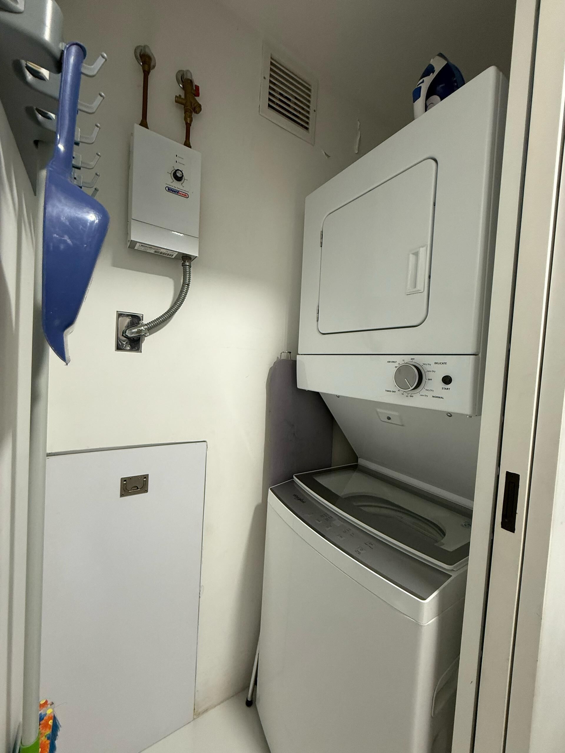 Een praktische wasruimte met een wasmachine, droger en een boiler.