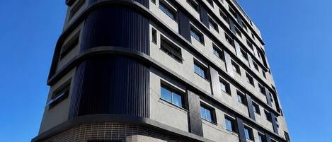 Un edificio de hotel de varios pisos con un llamativo letrero de 'UNY Hotels' en la fachada.