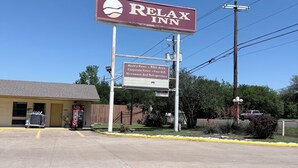 A Relax Inn motel táblája, amelyen a kínált szolgáltatások szerepelnek, többek között a heti árak, a grillező, a vállalati árak, az ingyenes Wi-Fi, valamint a mikrohullámú sütő és a hűtőszekrény.