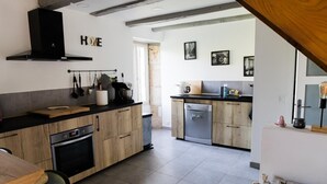 Eine moderne Küche mit Holzausstattung, einer schwarzen Arbeitsplatte und einem eingebauten Backofen.