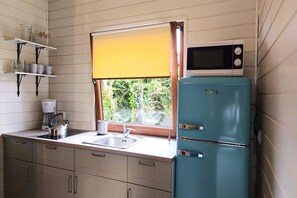 A compact kitchen with a sink, a stove, and a blue refrigerator. - Holiday home with fireplace and large terrace (Kopalino)