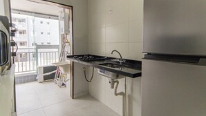 Eine Küche mit einem Edelstahl-Kühlschrank, einem Gasherd und einer Spüle.