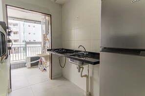 Eine Küche mit einem Edelstahl-Kühlschrank, einem Gasherd und einer Spüle.