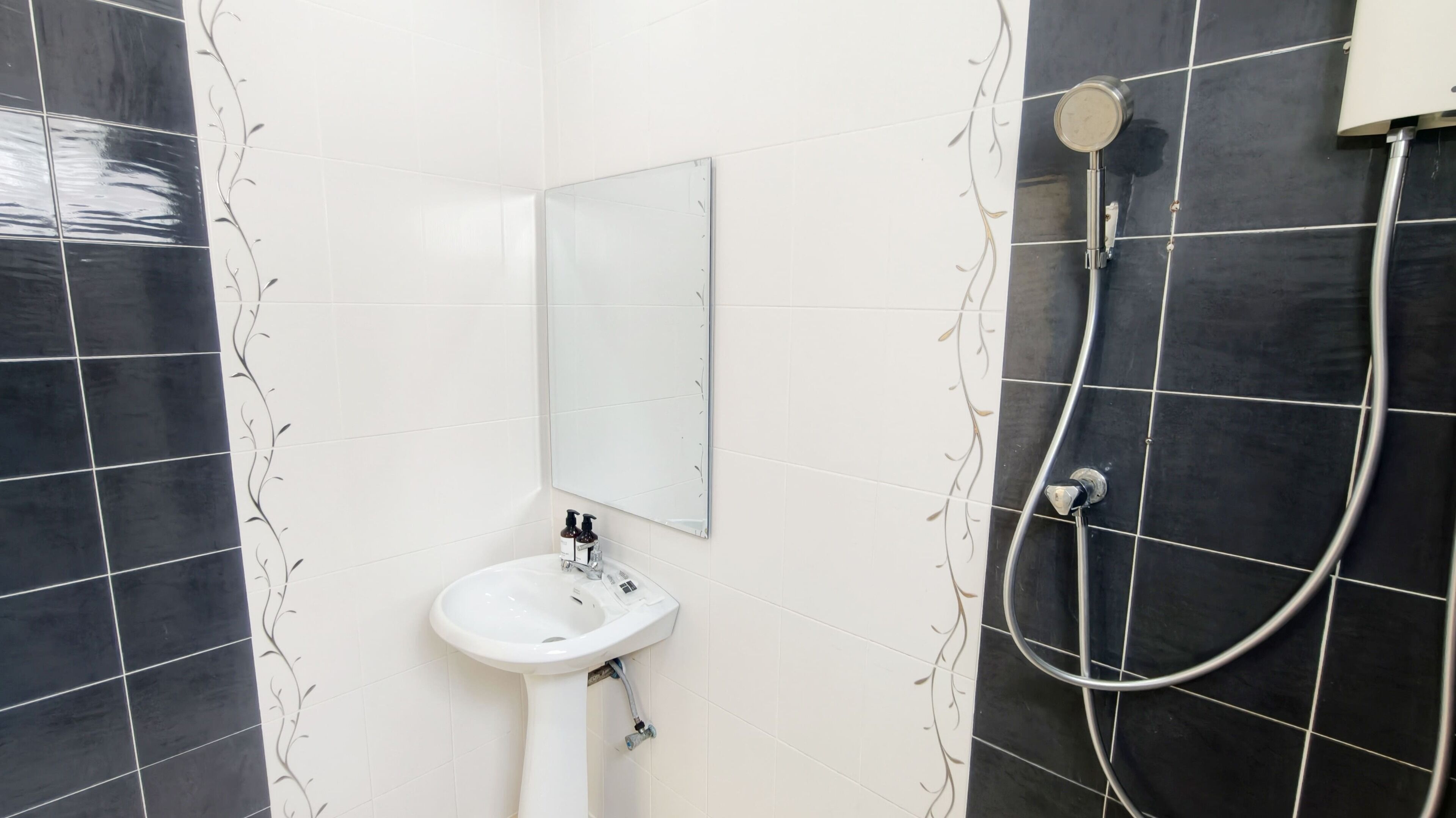 A bathroom with a white sink, a mirror, and a shower.