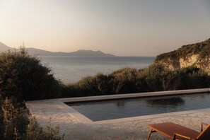 A swimming pool with a view of the sea and mountains. - PHÂRUS Meganisi | Boutique Villa with Private Pool & Sea View (Lefkada)