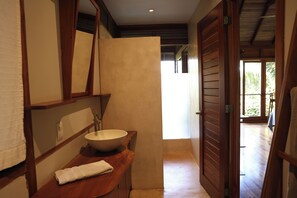 Un bagno con uno specchio grande, un lavandino e un asciugamano sul ripiano.