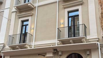 En bygning med flere etager, altaner, en stor buegangsindgang og et skilt der viser 'Superline Suites'.