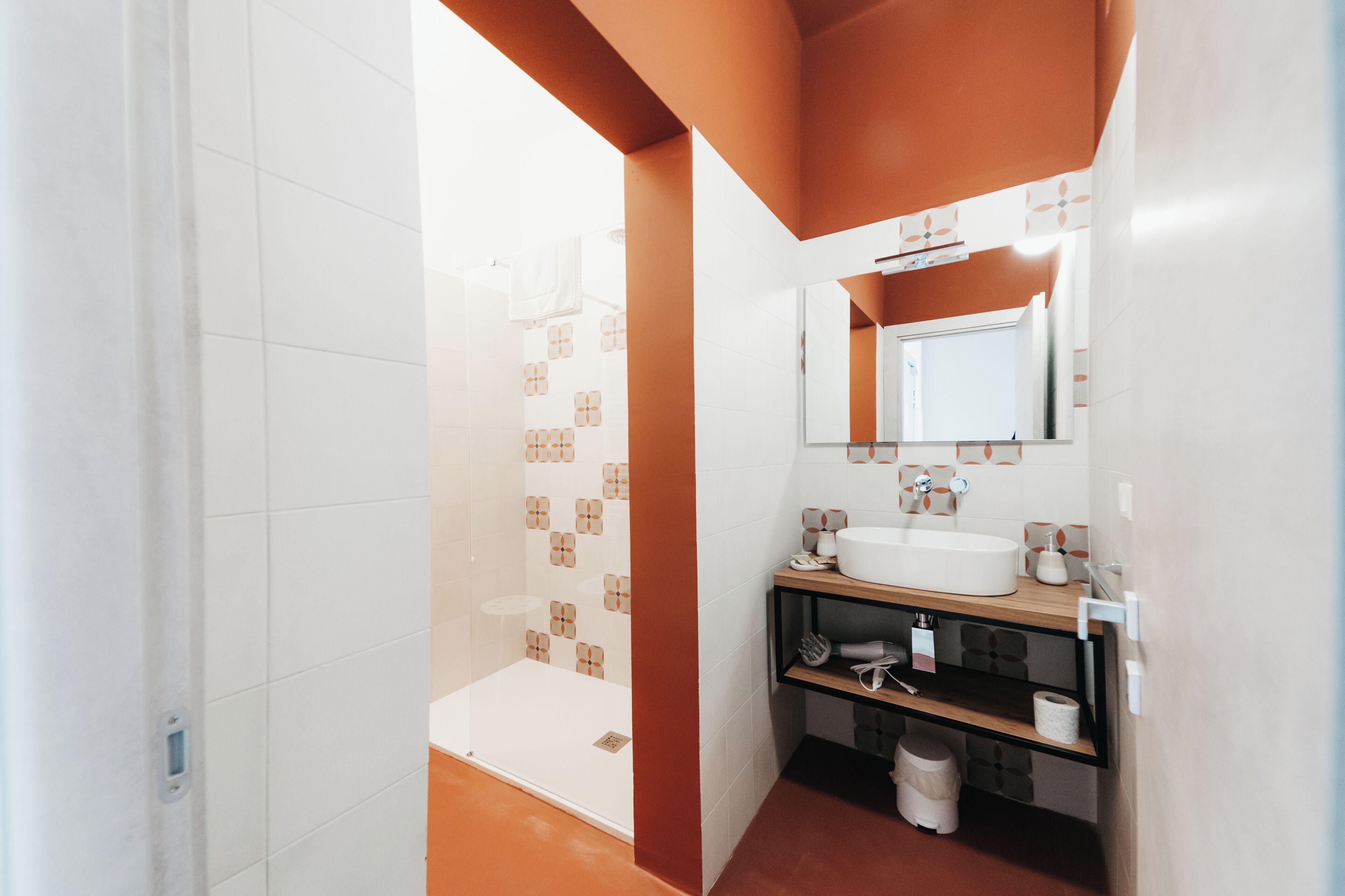 Une salle de bain moderne avec une douche, un lavabo et un miroir.