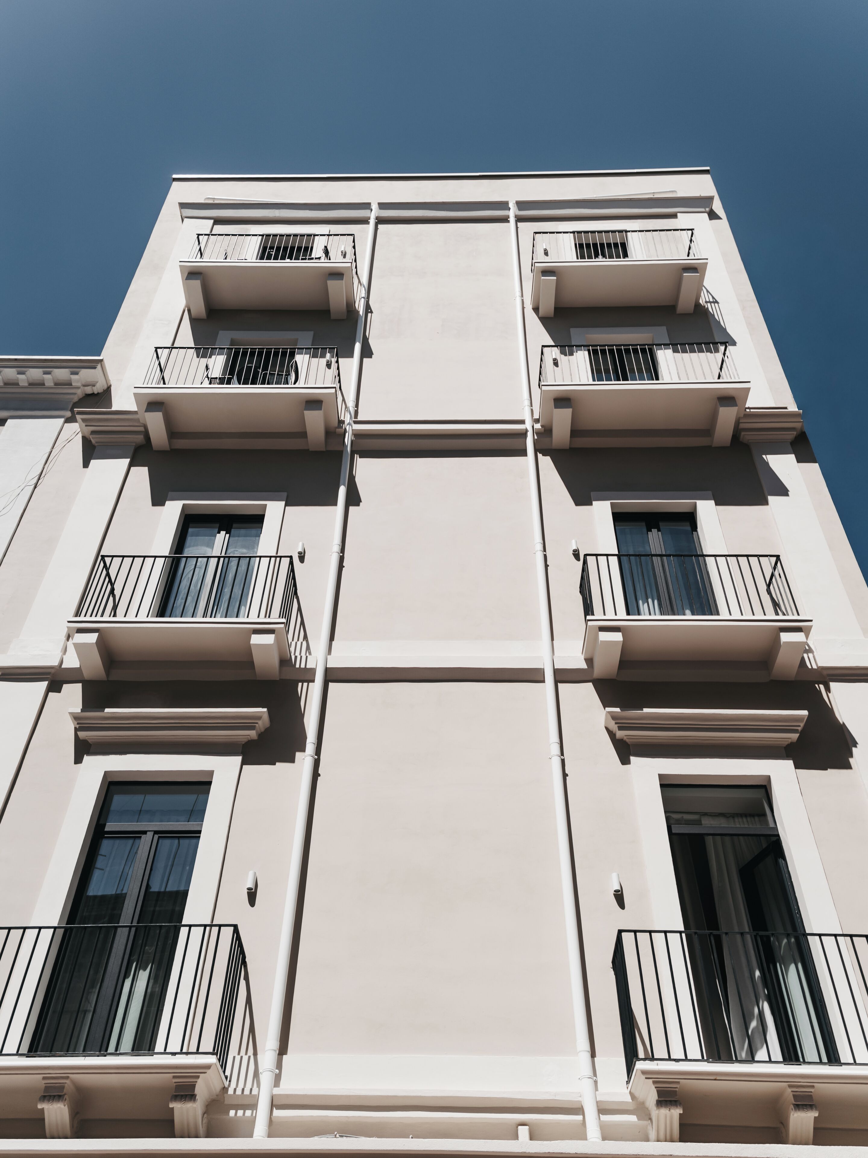 A multi-story building with balconies, large windows, and a flat facade.