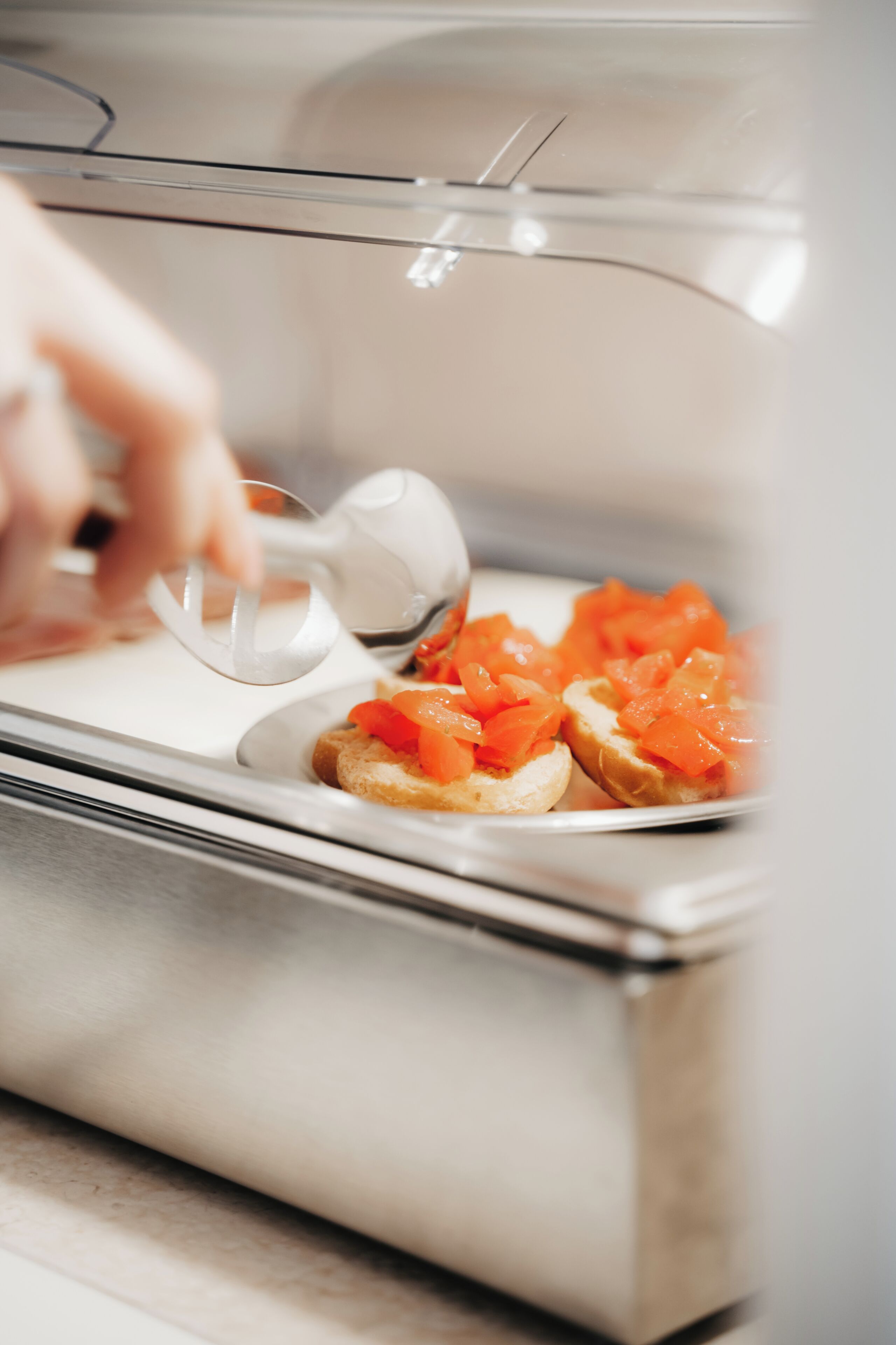 A person using a spoon to serve food from a container.