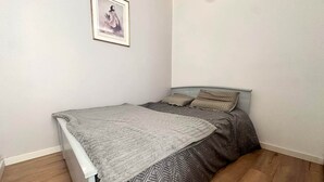 A small, neatly arranged bedroom with a bed, a framed picture on the wall, and wooden flooring. - Seafoam - T1 BIS near the ocean (Mimizan)