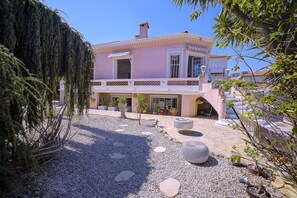A two-story building with a balcony, a gravel courtyard, and potted plants. - Souplex villa Nice Fabron exclusive pool sea view, 3 min beach, streetcar, shops (Nice)