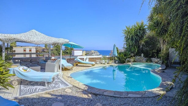 A pool area with lounge chairs, umbrellas, and a view of the sea. - Souplex villa Nice Fabron exclusive pool sea view, 3 min beach, streetcar, shops (Nice)