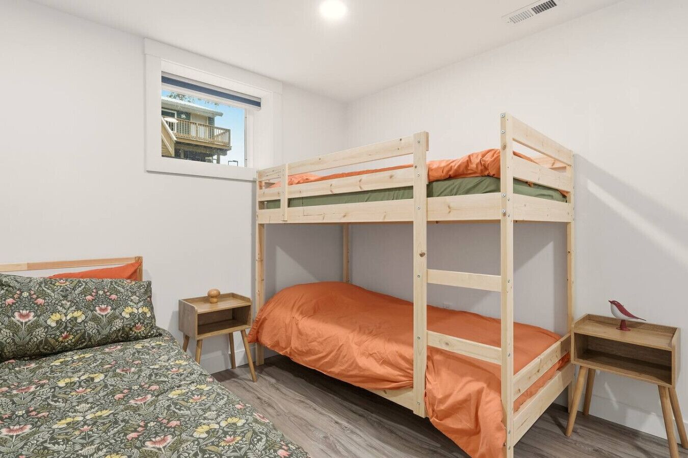 Una stanza con un letto a castello, una finestra, una scrivania e una sedia.