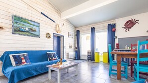 Un ambiente accogliente con un divano blu, un tavolo in legno e un'area pranzo con sedie.