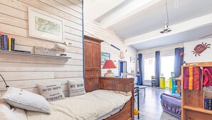 Una stanza accogliente con un letto di legno, una mappa appesa al muro e una libreria.