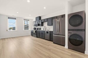 Una cocina moderna con electrodomésticos de acero inoxidable, un ventanal y vistas al exterior.