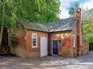 A brick cottage with a white door, a blue window, and a sign reading 'Stableyard Cottage.' - Osbaston Mews - Stableyard Cottage (Market Bosworth)