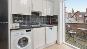Een moderne keuken met witte kasten, een wasmachine en een vaatwasser.
