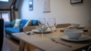 Een eettafel met twee wijnglazen, een schaal en bestek.