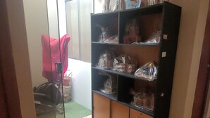 A room with a sliding glass door leading to a balcony, a black shelving unit with drawers, and a red chair. - Giovi's House (Moquegua)